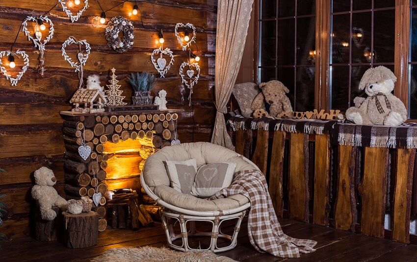 Wooden decorative fireplace papasan chair teddy bears by the window and bulbs light in holiday rural living room