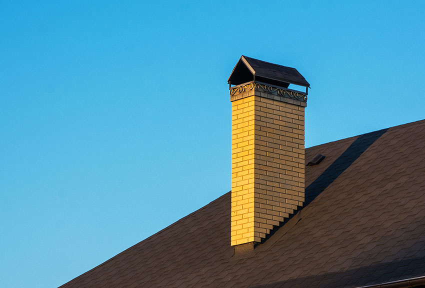 Asphalt roof with masonry brick chimney