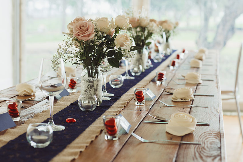Long dining table with decorations flowers and table runner