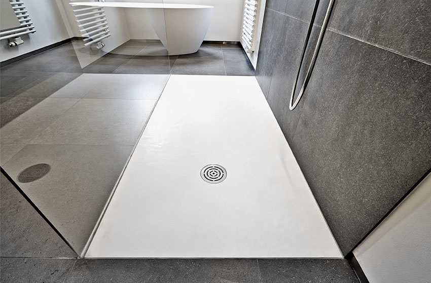 Shower with black wall tiles and white pan