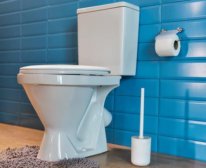 An upflush toilet rug and blue subway tile wall in a modern bathroom