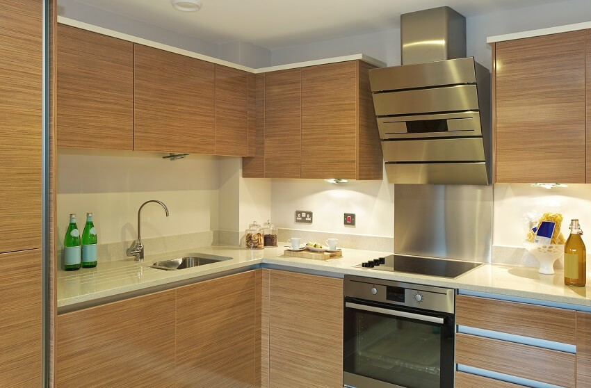 Kitchen with ceramic countertops, bottles of water, sink and faucet