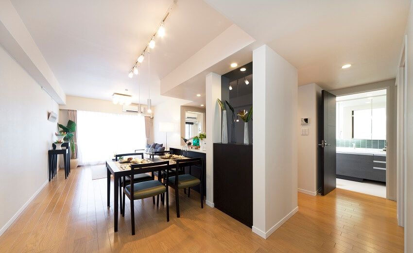 Light wood floor tiles, white walls with view of the bathroom