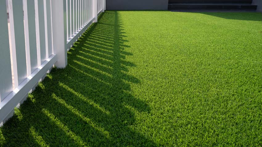 Artificial turf beside a white fence