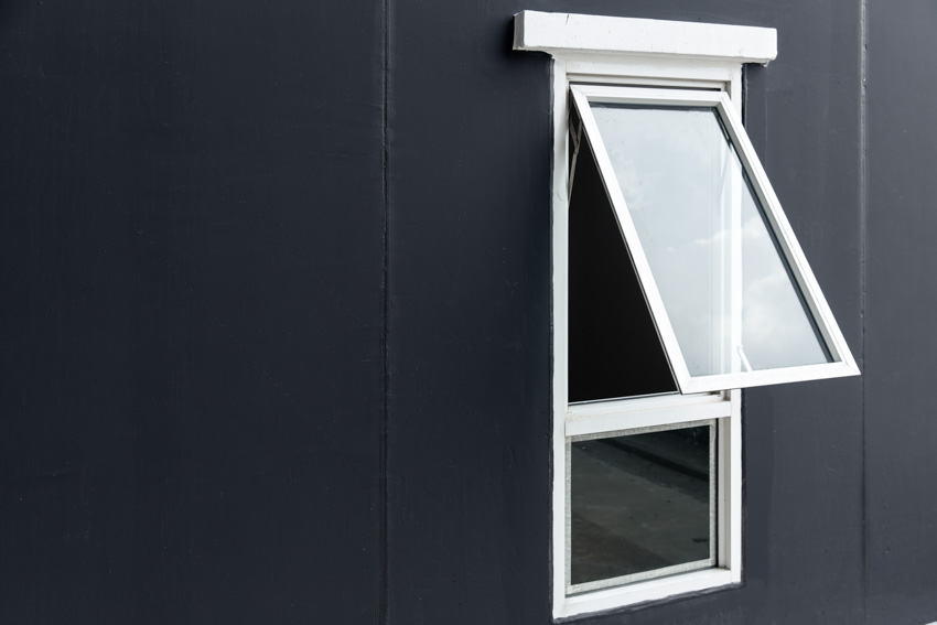 Awning window installed on a black house exterior