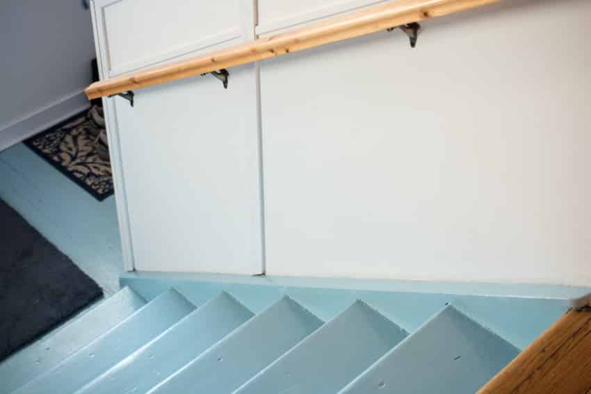 Basement stairs with painted steps and hand railing