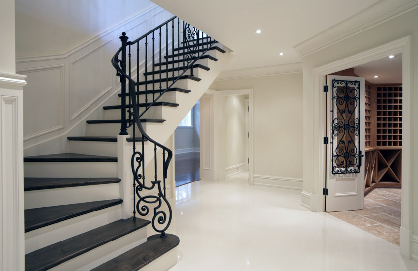 Basement with stair steps, metal railing, and painted white floor