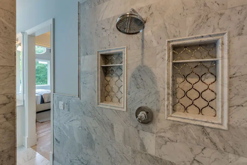 Bathroom shower area with Carrara marble wall, and shower head