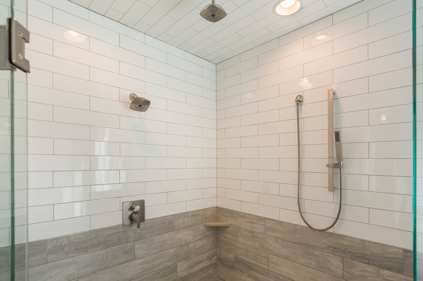 Bathroom shower with subway tile and recessed lighting fixtures
