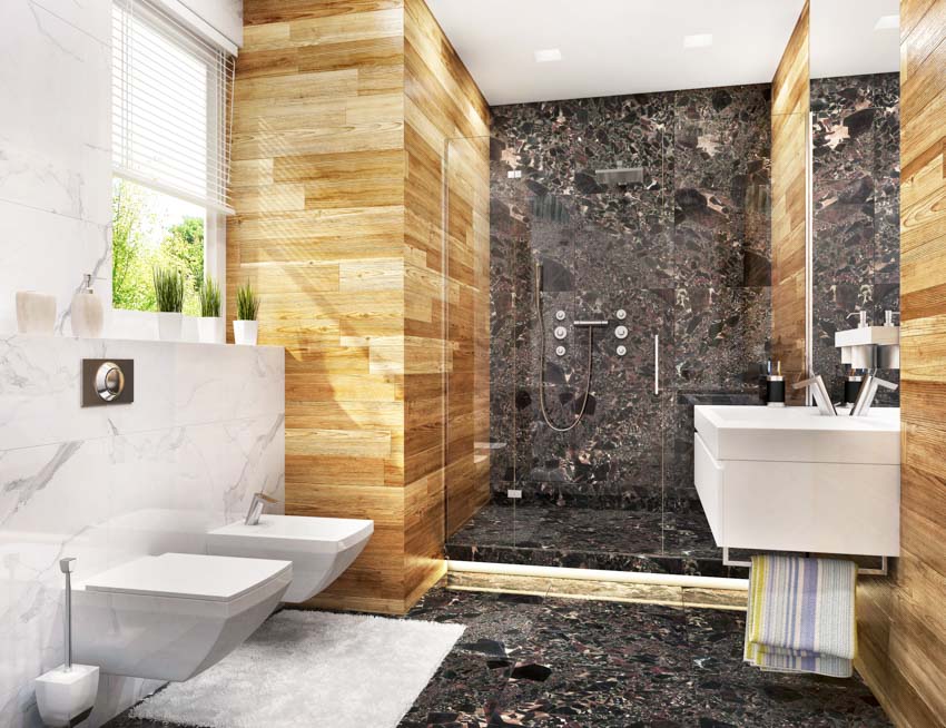 Bathroom with the pros and cons of onyx showers, wood accent wall, toilet, sink, and window