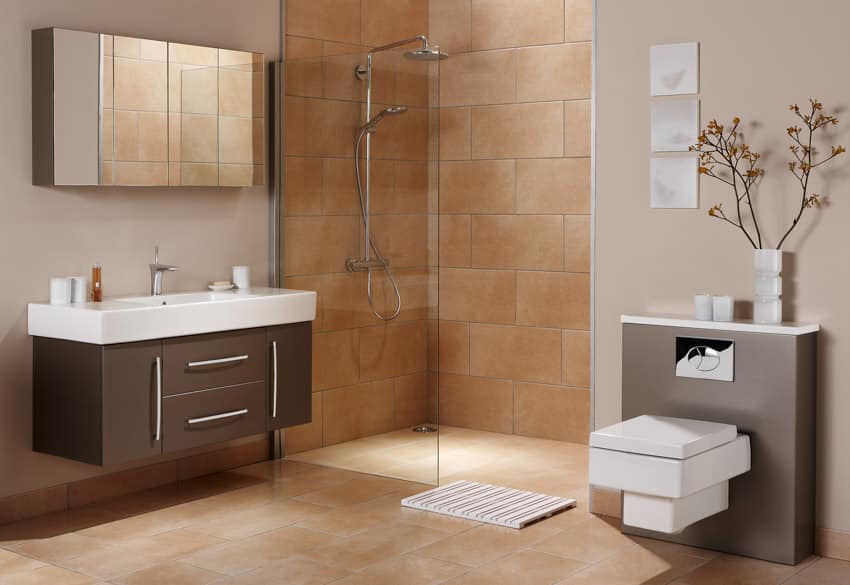 Bathroom with shower area, glass divider, mirror, toilet, sink, countertop, tile wall, and floor