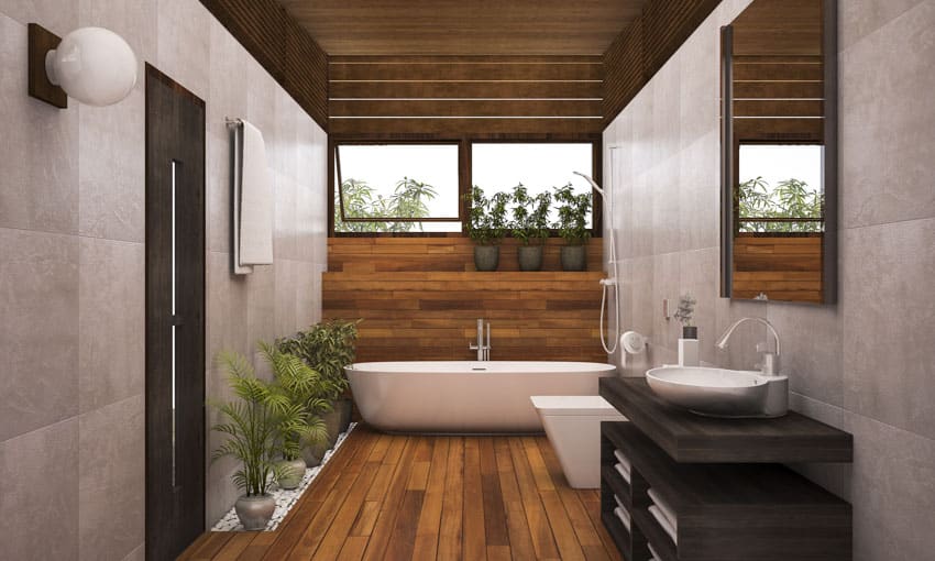 Bathroom with wood accent wall, tub, mirror, sink, faucet and indoor plants