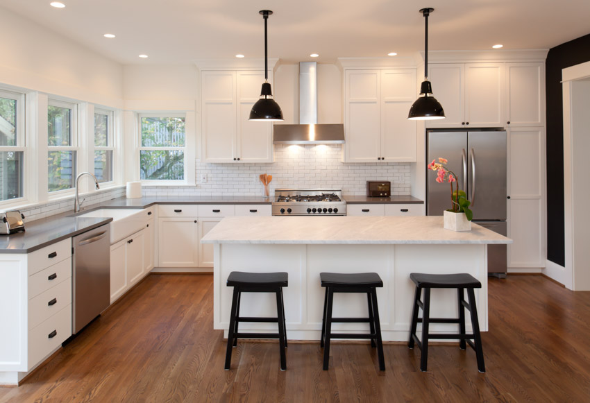 Beautiful kitchen pendant light countertop center island wood flooring windows drawers hood