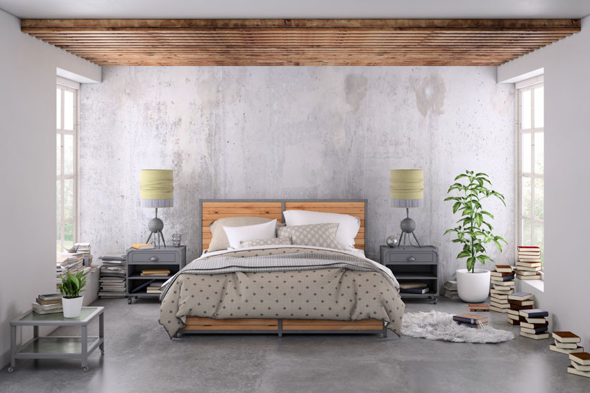 Bedroom with concrete wall, wood ceiling, nightstands, lamps, indoor plant, and windows