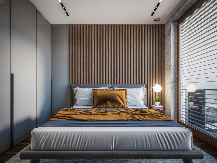 Bedroom with wood slat accent wall, windows, blinds, and nightstand