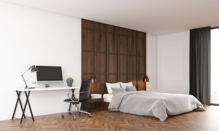 Bedroom with wood wall, home office space, and window curtains