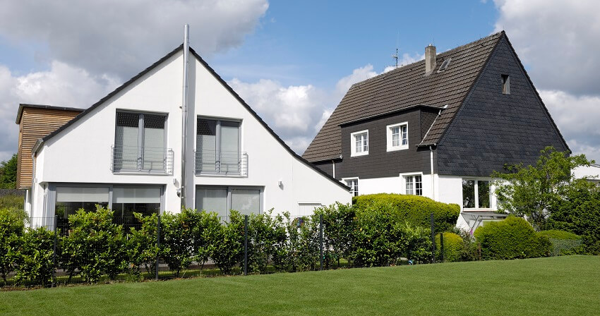 Black and white house with chimney lightning rod skylight window and a green lawn