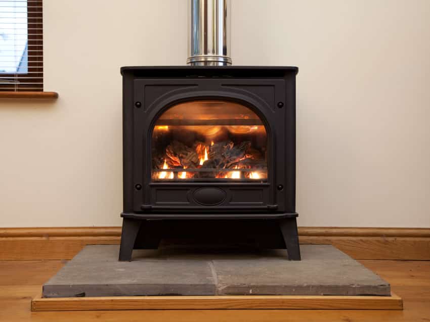Black steel fireplace with damper on wood floor