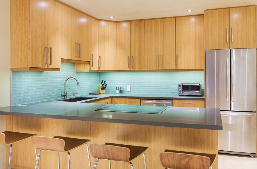 Kitchen with low-back stools and countertops with cooktop