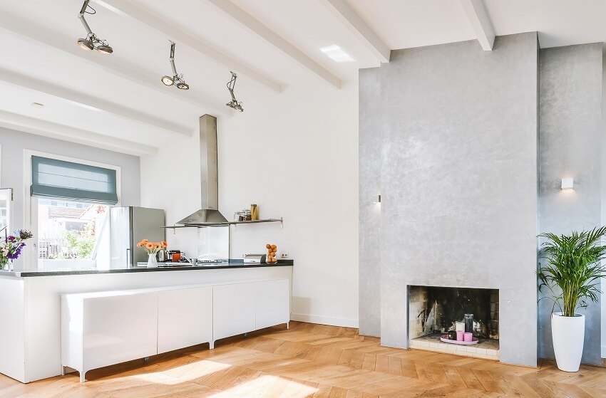 Open area with ceiling beams, granite countertops with grey accent wall