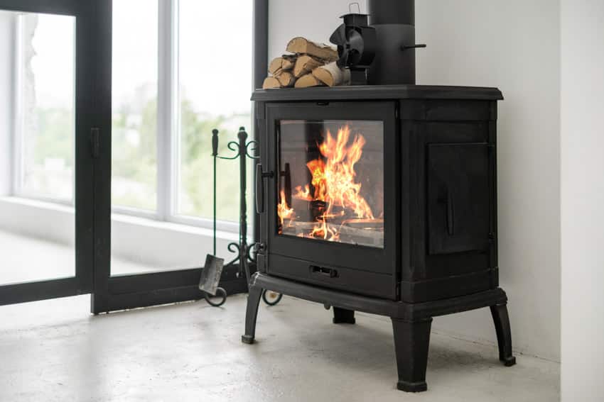 Classic black fireplace with throat type fireplace damper, poker, and firewood