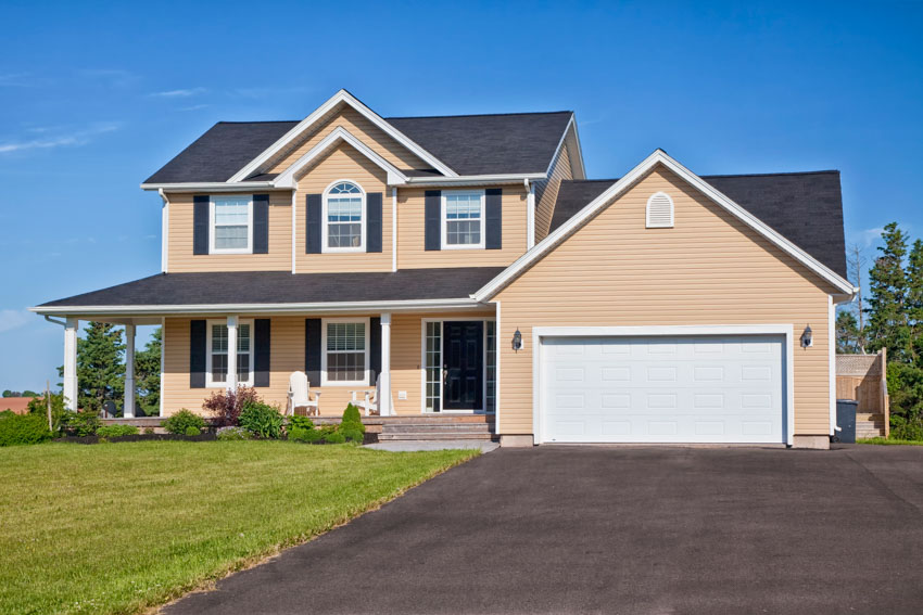 House with siding, porch with white columns and car port