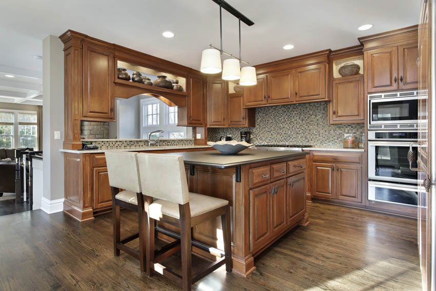 Rustic kitchen with center island, oak cabinets, tile backsplash and pendant lights