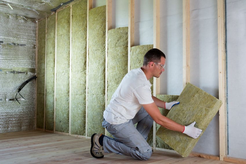 Contractor adding insulation to garage walls