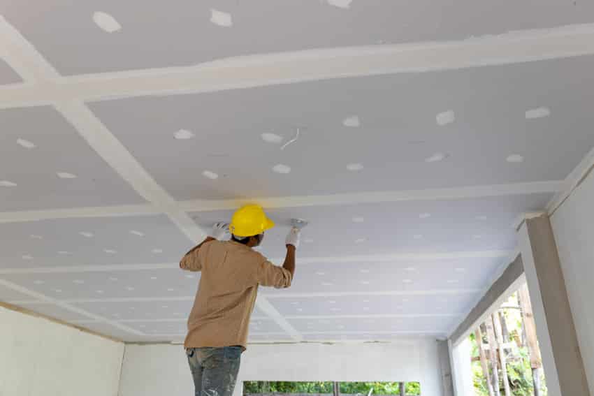 Contractor checking the integrity of a drop ceiling