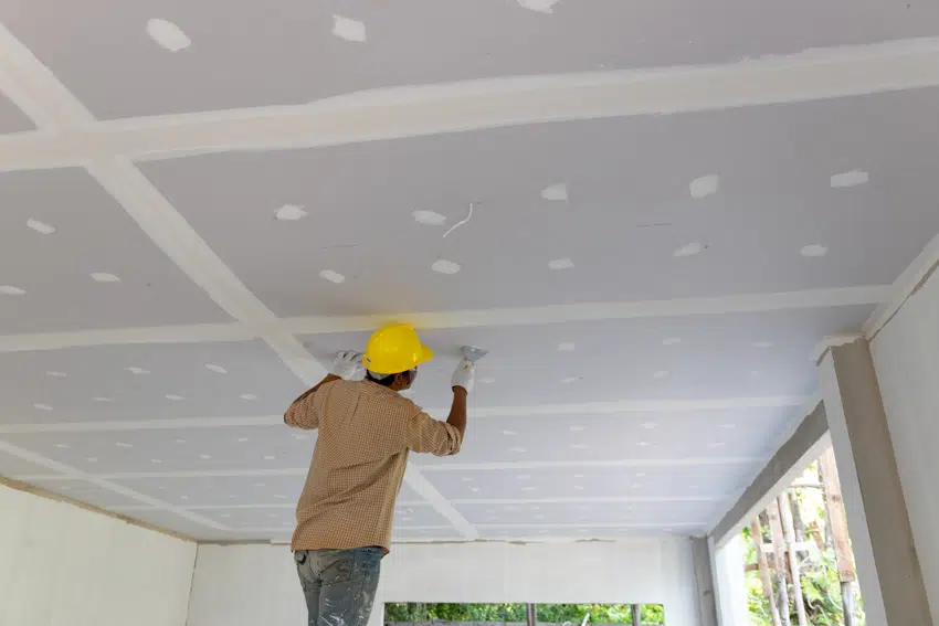 Contractor checking the integrity of a drywall ceiling