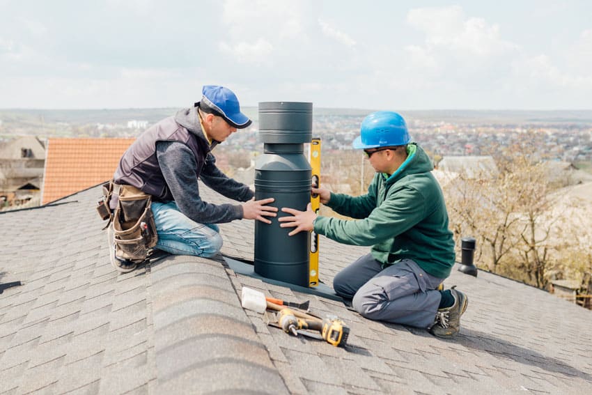 Contractors installing a top sealing damper on a chimney