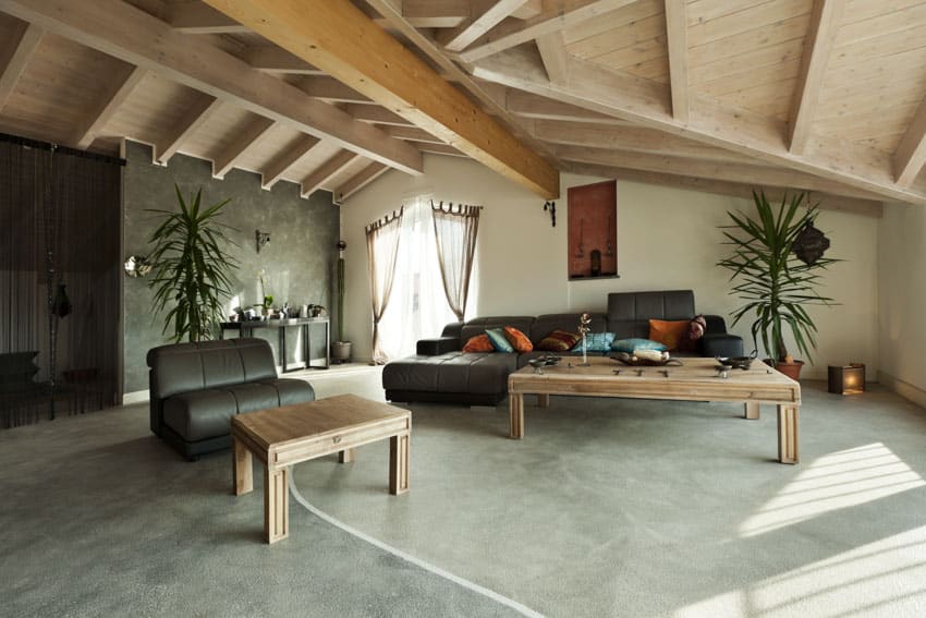 Cozy living space with couches, tables, concrete floor, and combination wood ceiling design