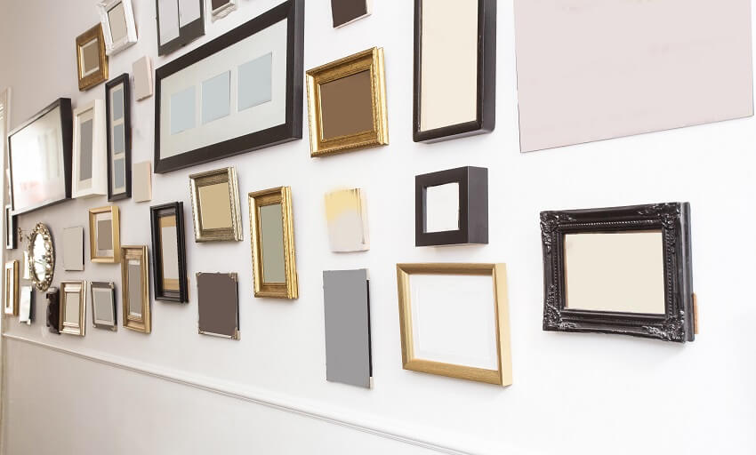 Different types of empty picture frames with vintage retro design on white wall