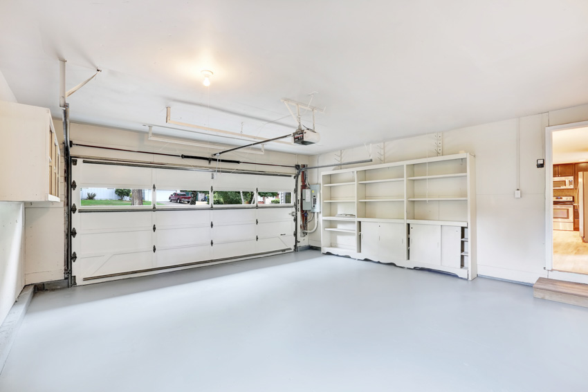 Garage with door opener, shelves, and sealed floor