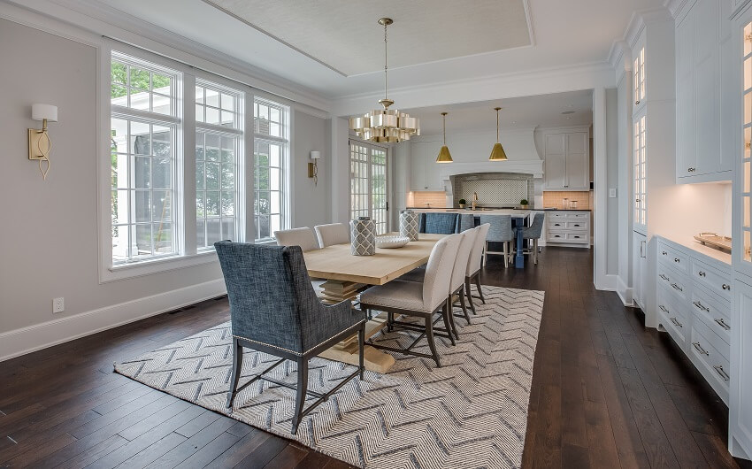 Dining area with light wood dining table, pendant lights and white cabinets 