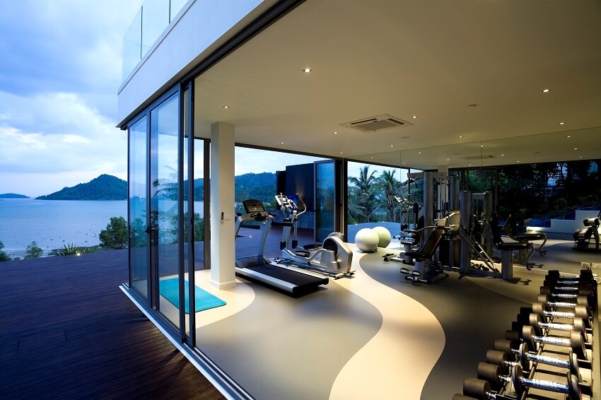 Gym with sliding glass doors large mirror and recessed lighting 