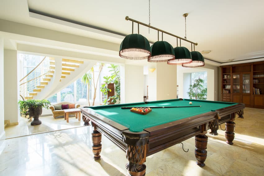 Game room with pool table, cabinet, tile floor, and pendant light