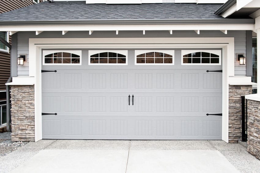 Garage door with smalll windows and a concrete driveway