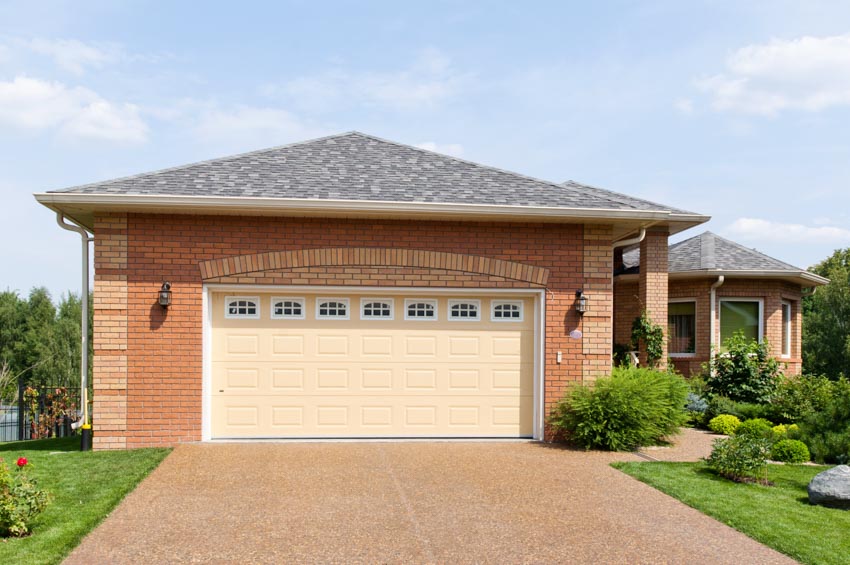 Garage with brickwall and colored driveway