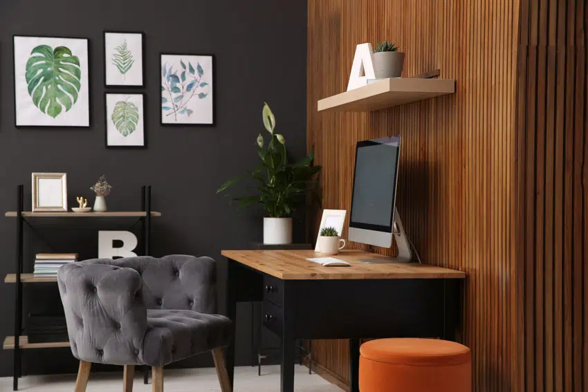 Study room with black walls and orange ottoman and wall art
