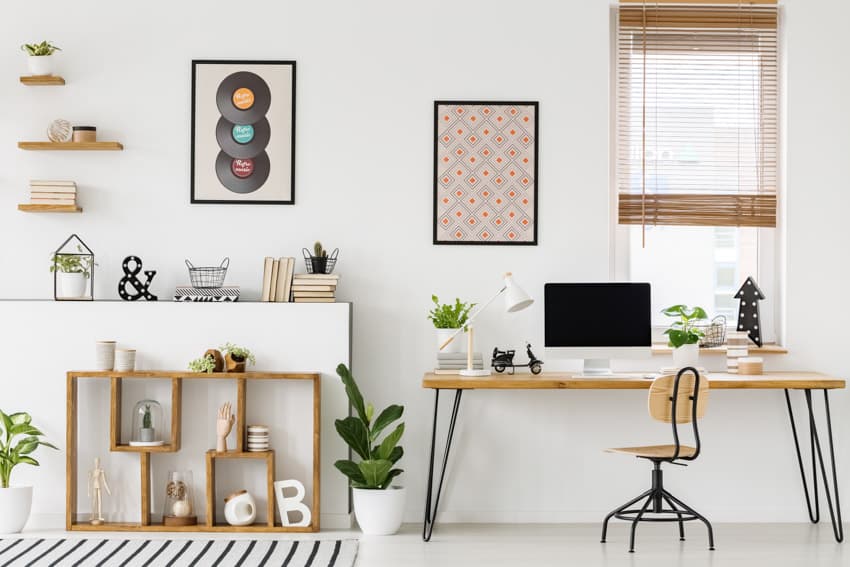 Home office with window, computer table, chair, vinyl record as wall decor, and floating shelves