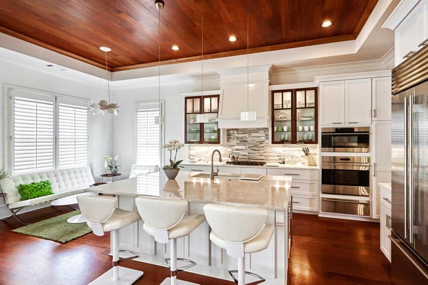 Kitchen area with wooden ceiling, pendant lights, recessed lighting fixtures, center island, cabinets, and windows