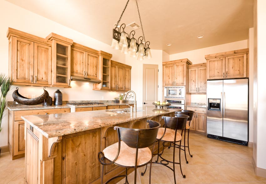 Kitchen space with center island, cabinetry, pendant light, countertops, and chairs