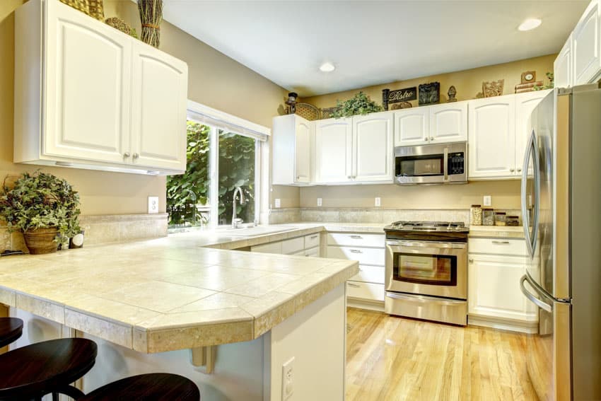Kitchen space with white cabinets, countertop, and wood floors