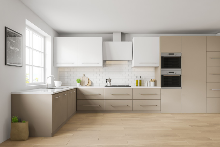 Kitchen with beige cabinets, wood flooring, countertop, window, and backsplash