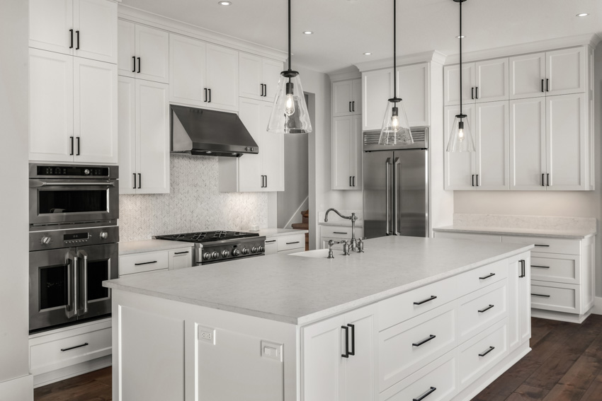 Kitchen with center island, white cabinets, honed quartzite, countertop, and wood flooring