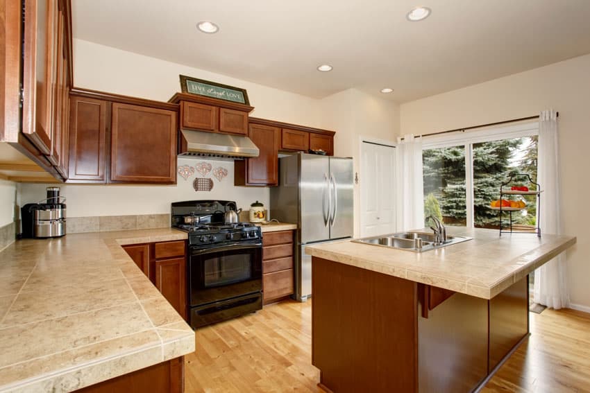 Kitchen with island with dual sink, black oven and hood