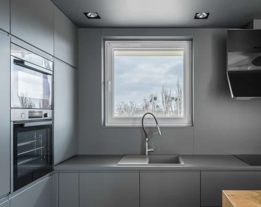 Kitchen with window, countertop, sink, faucet, and oven