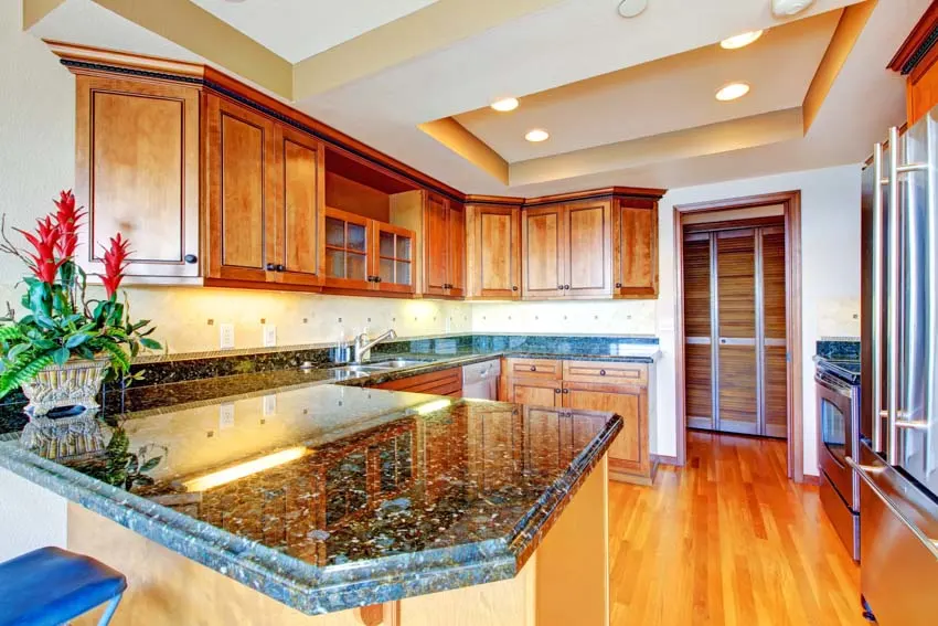 Kitchen with labradorite countertop, wood floor, cabinets, and ceiling lights
