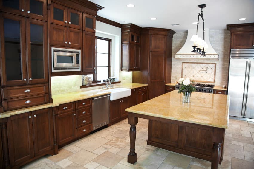 Kitchen with limestone countertop, wood cabinet, tile flooring, and pendant light